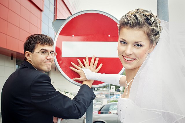 Brautpaar steht vor einem Stopschild