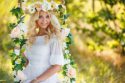 Portrait einer schönen Braut auf Blumenschaukel mit Blumenkrone